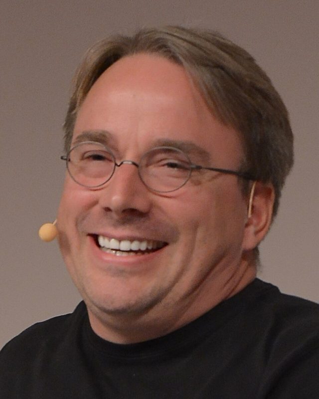 Linus Torvalds sonriendo con un micrófono de diadema en la LinuxCon Europe de 2014