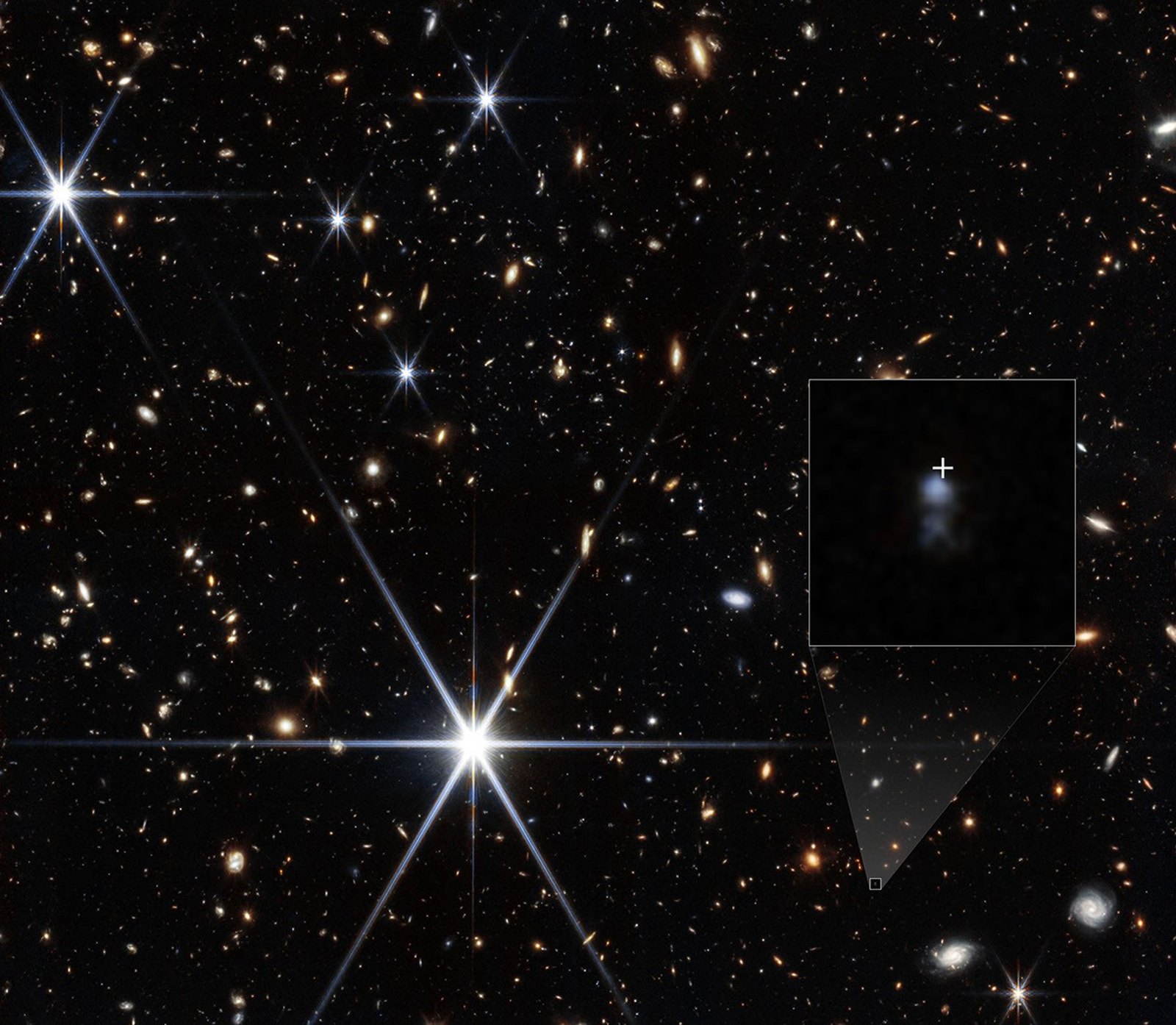 Campo de galaxias captado por NIRCam del telescopio James Webb, con un recuadro ampliado de la pequeña galaxia anfitriona de la ráfaga FRB 20240304B, marcada con una cruz